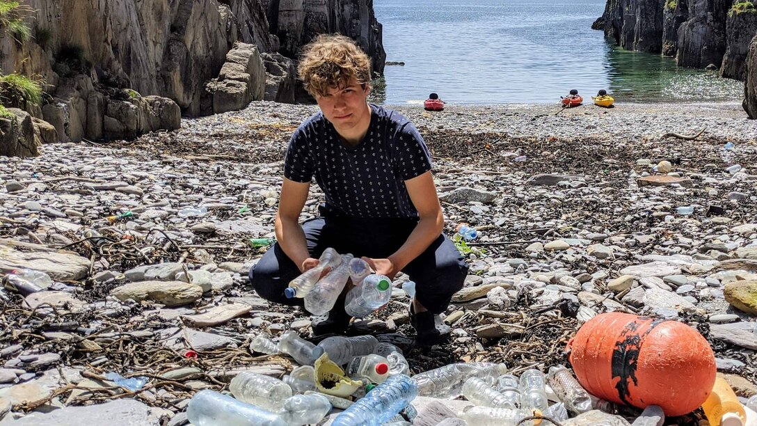 Fionn Ferreira am Strand mit diversen Plastikabfällen.  | © Fionn Ferreira